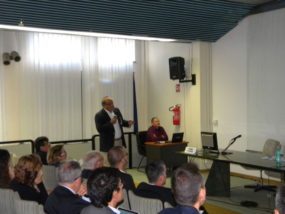 Un relatore in piedi con il microfono risponde alle domande della sala